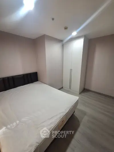 Spacious bedroom with modern design and ample storage in a stylish apartment.