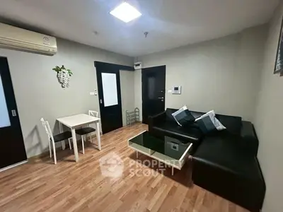 Modern living room with sleek black sofa and stylish coffee table, perfect for urban living.