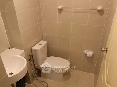 Compact bathroom with modern fixtures and neutral tile design, ideal for efficient space utilization.