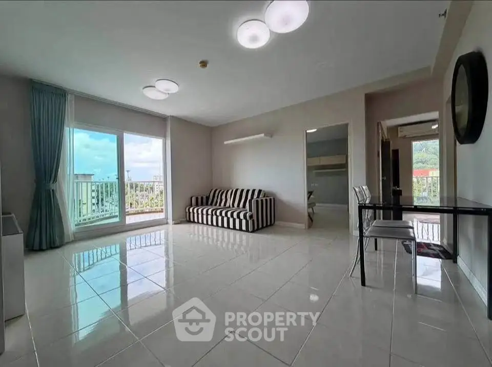Spacious living room with modern decor and large windows offering a scenic view.