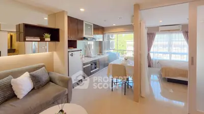 Modern open-plan studio apartment with stylish kitchen and cozy living area, featuring large windows for natural light.