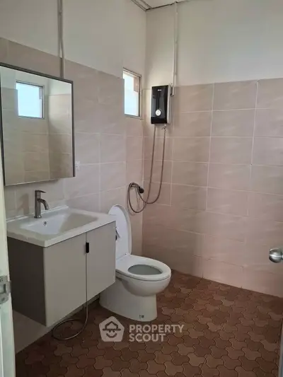 Modern bathroom with sleek fixtures and neutral tiles, featuring a shower and vanity unit.