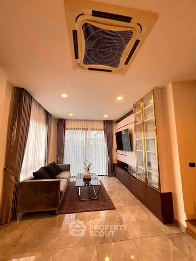 Luxurious living room with modern decor, large windows, and elegant furnishings.