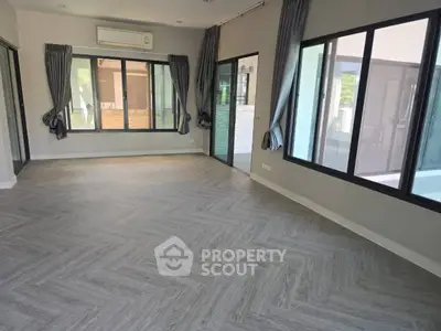 Spacious modern living room with large windows and elegant flooring