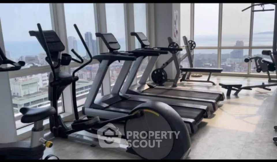 Modern gym with panoramic city views and state-of-the-art fitness equipment.