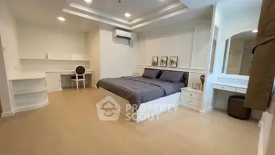 Spacious modern bedroom with elegant decor and ample natural light