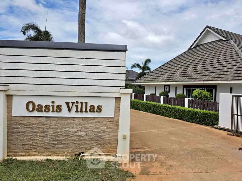 Charming Oasis Villas entrance with lush greenery and modern architecture.