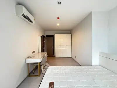 Spacious bedroom with modern furniture and air conditioning in a minimalist design.