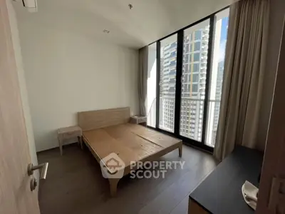 Modern bedroom with large windows and city view in high-rise apartment