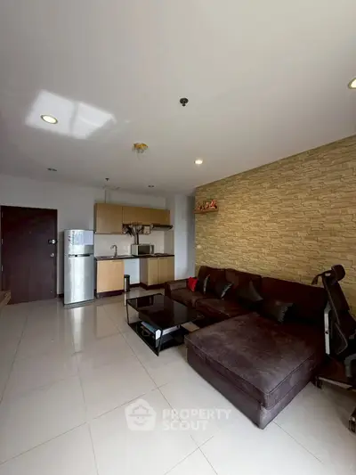 Modern living room with open kitchen, stylish decor, and cozy seating area.