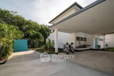 Modern house exterior with spacious driveway and lush greenery