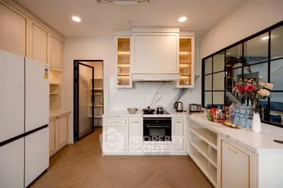Elegant kitchen with modern appliances and open layout, featuring sleek cabinetry and stylish decor.