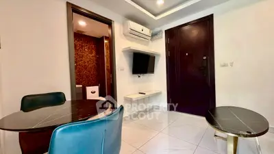 Modern apartment interior with sleek furniture and wall-mounted TV, featuring a glimpse into a stylish bathroom.