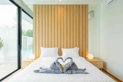 Luxurious modern bedroom with elegant decor and large windows offering natural light.