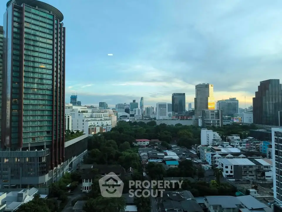 Stunning cityscape view from high-rise building showcasing urban skyline and lush greenery.