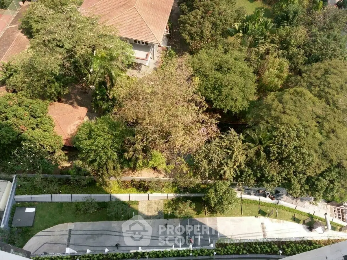 Aerial view of lush garden and residential building with tiled roof.