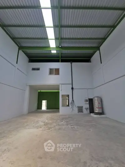 Spacious industrial warehouse with high ceilings and ample natural light.