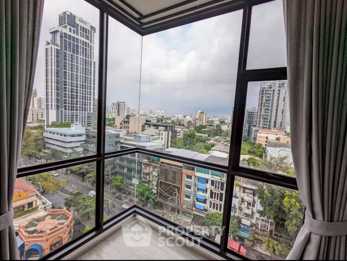 Stunning cityscape view from a high-rise apartment corner unit with floor-to-ceiling windows.
