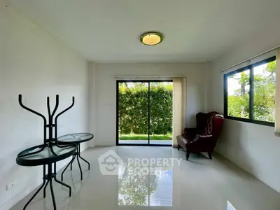 Spacious living room with garden view and elegant armchair