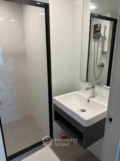 Modern bathroom with sleek shower and stylish sink in contemporary apartment.