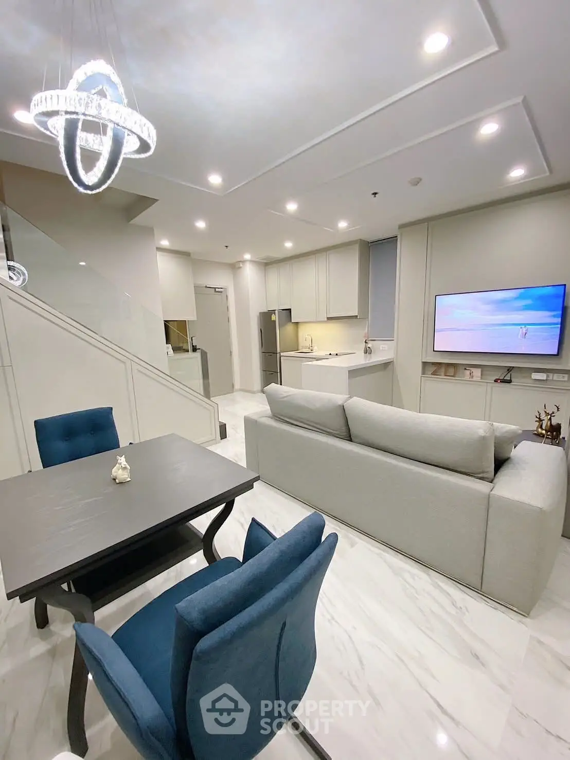 Modern open-plan living room with elegant dining area and stylish lighting