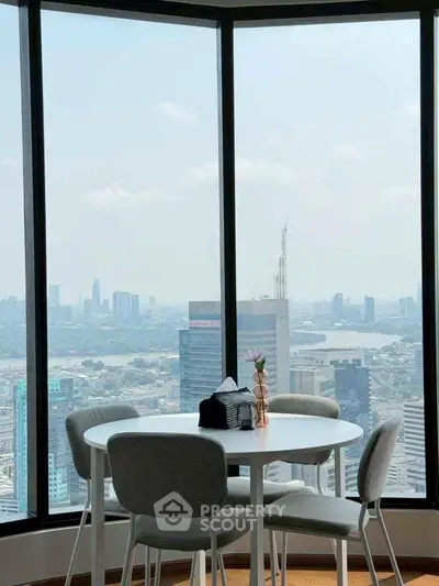 Stunning cityscape view from modern dining area with large windows in high-rise apartment.
