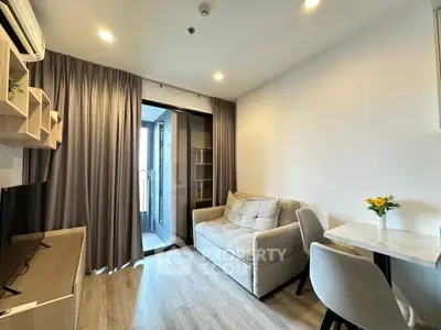 Modern living room with cozy sofa and balcony access in a stylish apartment.