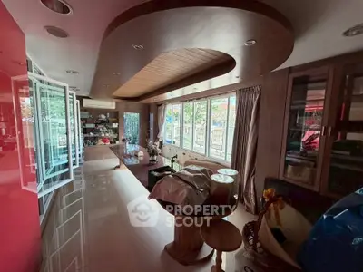 Spacious living room with modern design and large windows offering natural light and garden view.