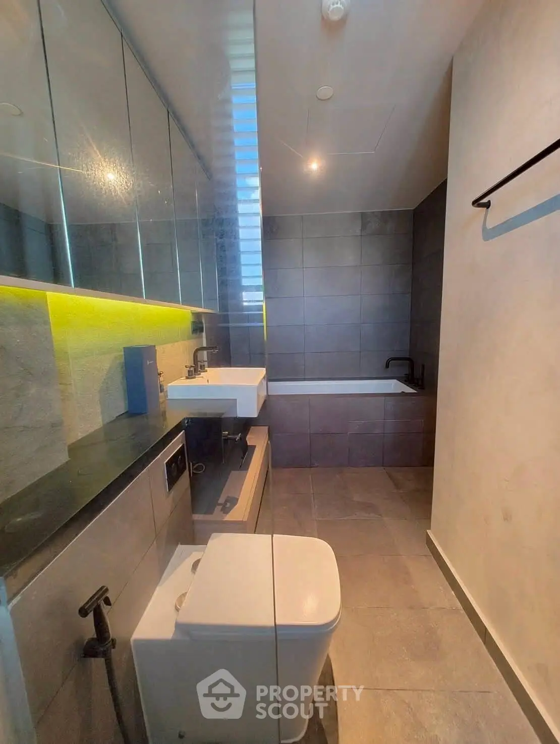 Modern bathroom with sleek design and bathtub, featuring elegant fixtures and ambient lighting.