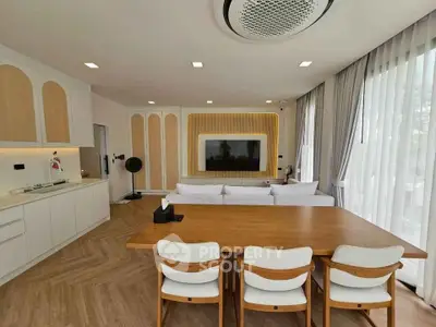 Modern open-plan living room with elegant dining area and large TV setup