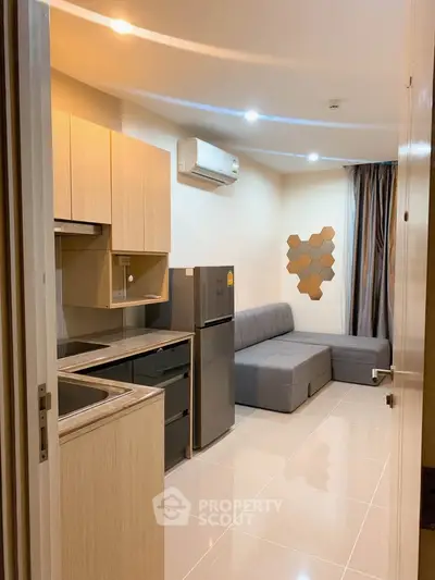 Modern apartment interior with sleek kitchen and cozy living area, featuring stylish furniture and contemporary design.