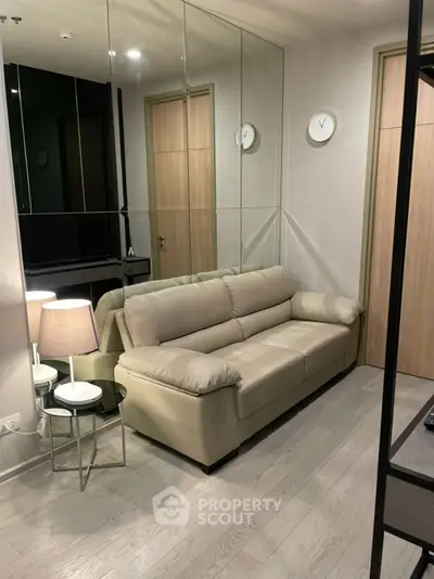 Modern living room with beige sofa and mirrored wall for spacious feel
