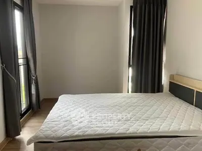 Spacious bedroom with large windows and modern decor, perfect for natural light lovers.
