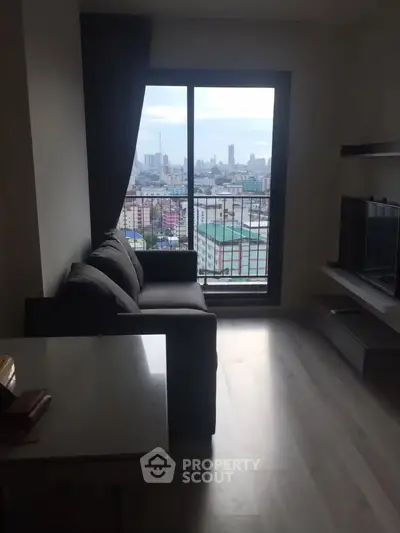 Modern living room with city view, featuring a sleek sofa and large window for natural light.