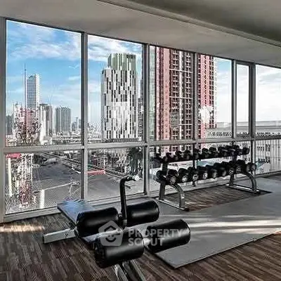 Modern gym with city view and state-of-the-art equipment in high-rise building.
