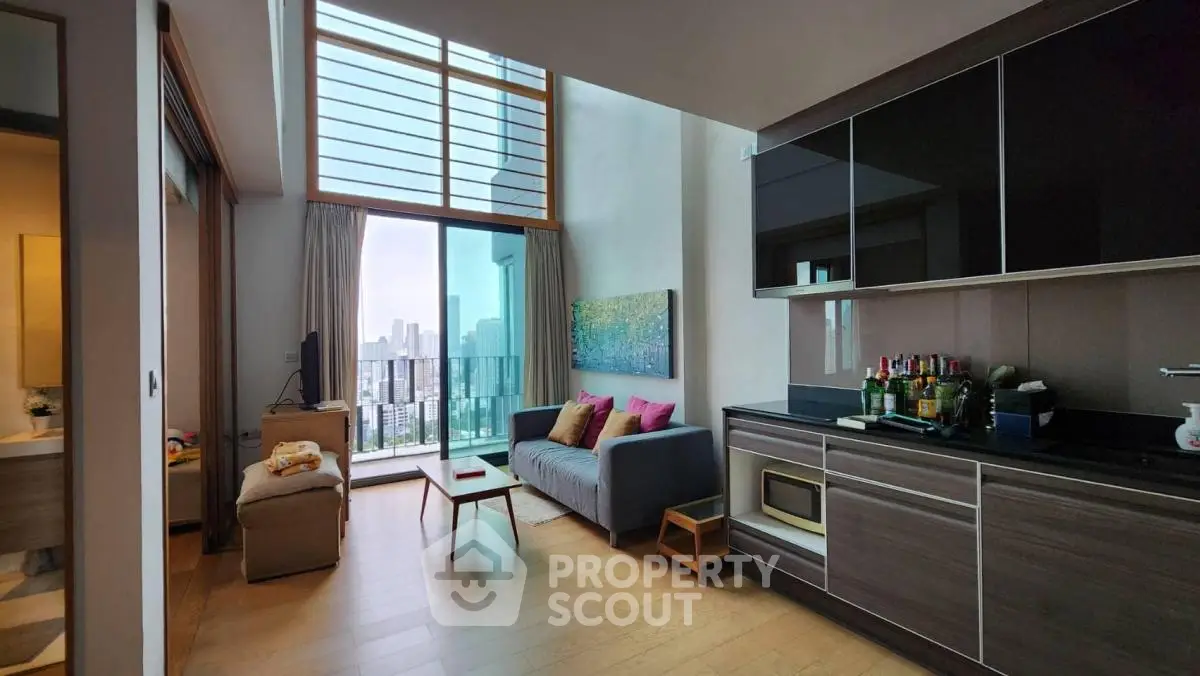 Modern living room with balcony and city view, featuring sleek cabinetry and cozy seating area.