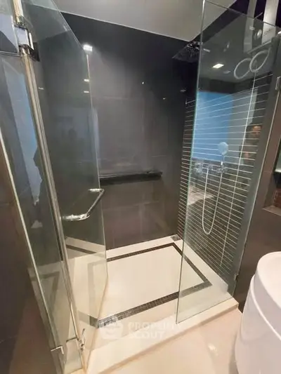 Modern bathroom with sleek glass shower enclosure and contemporary design.