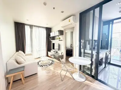 Modern living room with balcony access and stylish decor in a bright apartment.