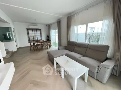 Spacious modern living room with elegant dining area and large windows for natural light.