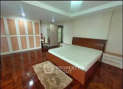 Spacious bedroom with wooden flooring and ample wardrobe space