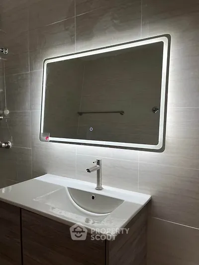 Modern bathroom with illuminated mirror and sleek sink design