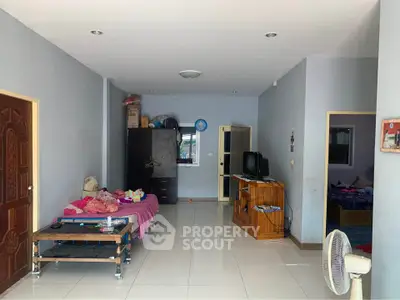 Spacious living room with tiled flooring and simple furnishings, ideal for customization.