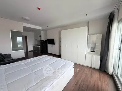 Spacious modern bedroom with large windows and sleek furnishings in a contemporary apartment.