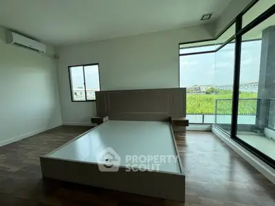 Spacious bedroom with large windows and modern design in a luxury apartment.