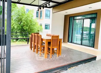 Spacious outdoor dining area with wooden table and chairs, perfect for entertaining guests.