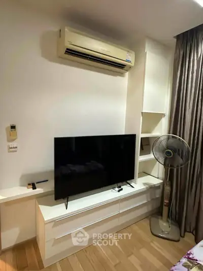 Modern living room with sleek TV setup and air conditioning, perfect for cozy entertainment.