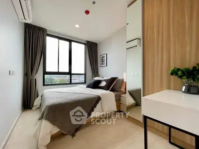 Modern bedroom with large window and stylish decor in a contemporary apartment.