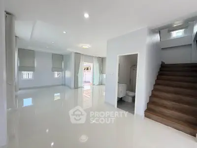Spacious modern living room with glossy floors and elegant staircase