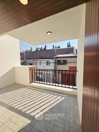Spacious balcony with modern design and street view, perfect for relaxation.