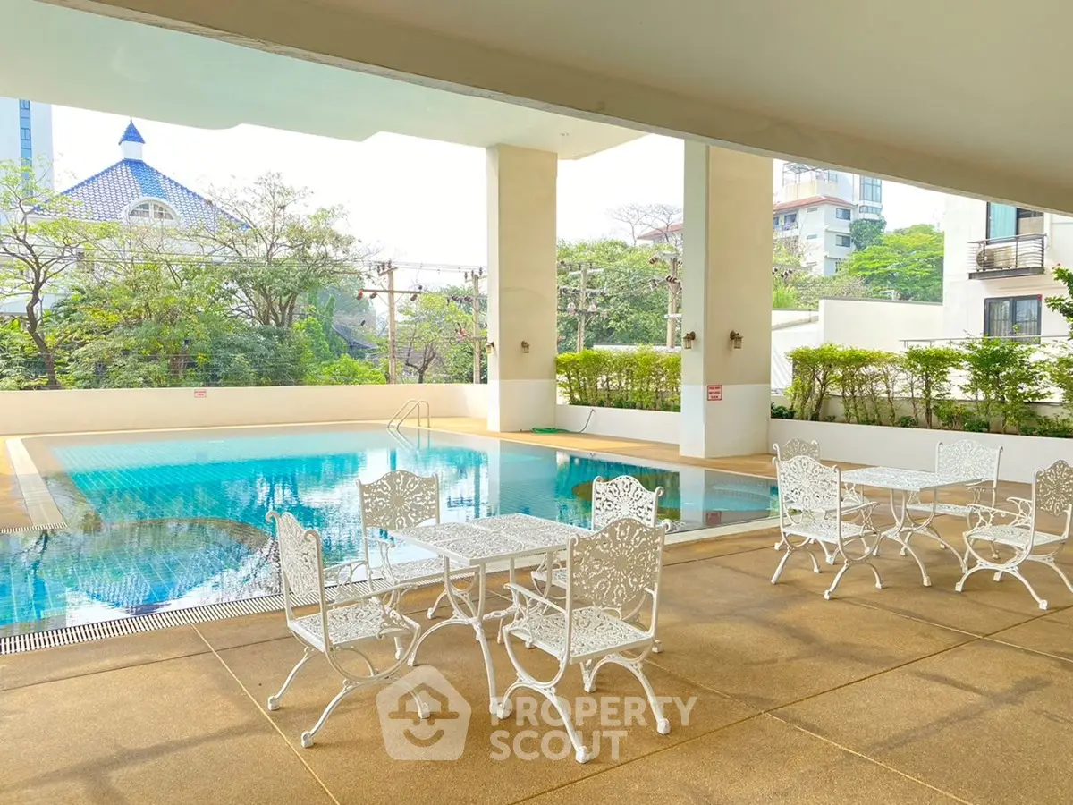 Luxurious outdoor pool area with elegant white furniture and scenic views, perfect for relaxation and leisure.